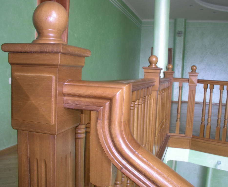 Классическая деревяная лестница, акцент на примыкании перил к столбу на втором этаже Арт 15